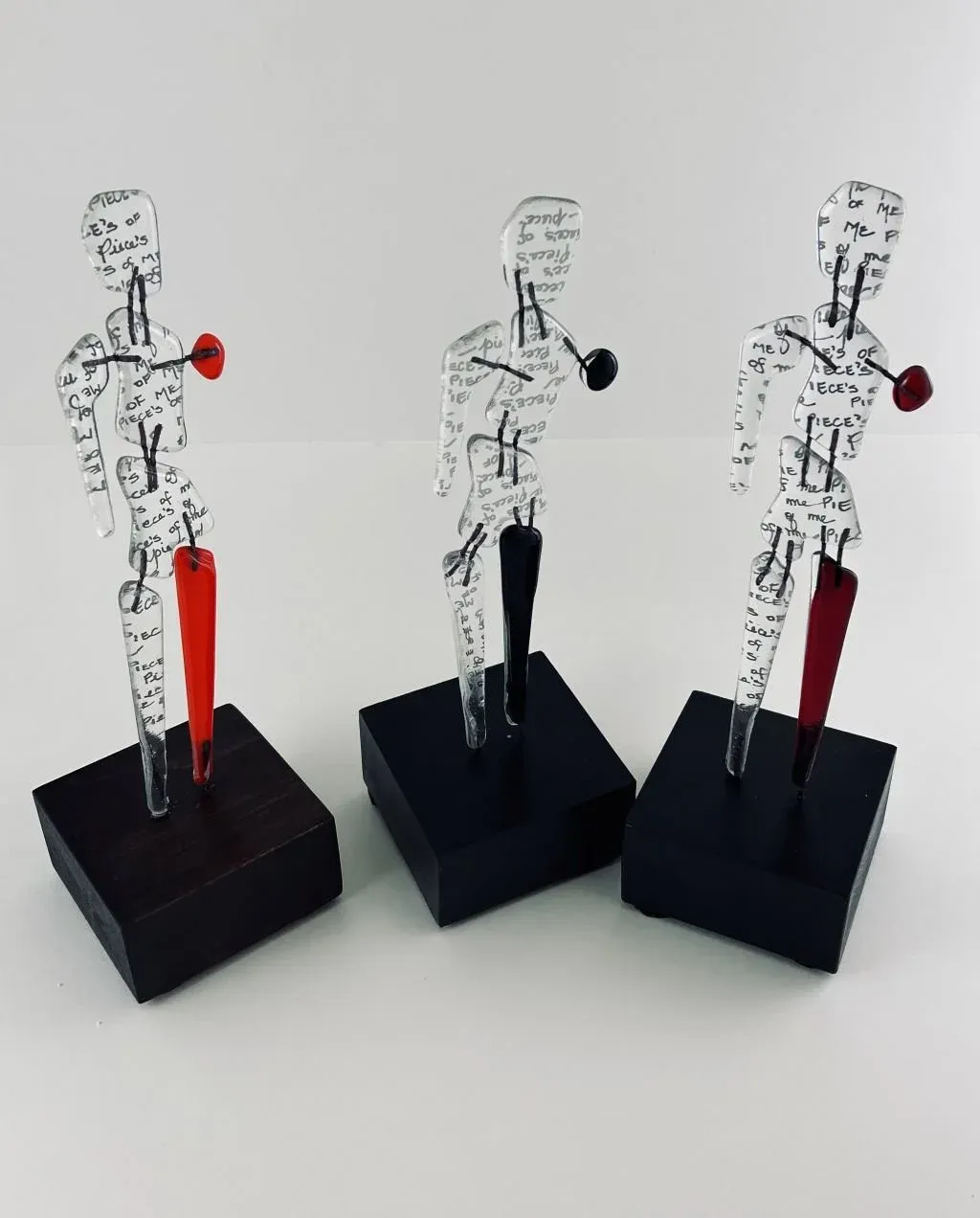 Pieces of Me: Kiln-fired glass figures on wood stands